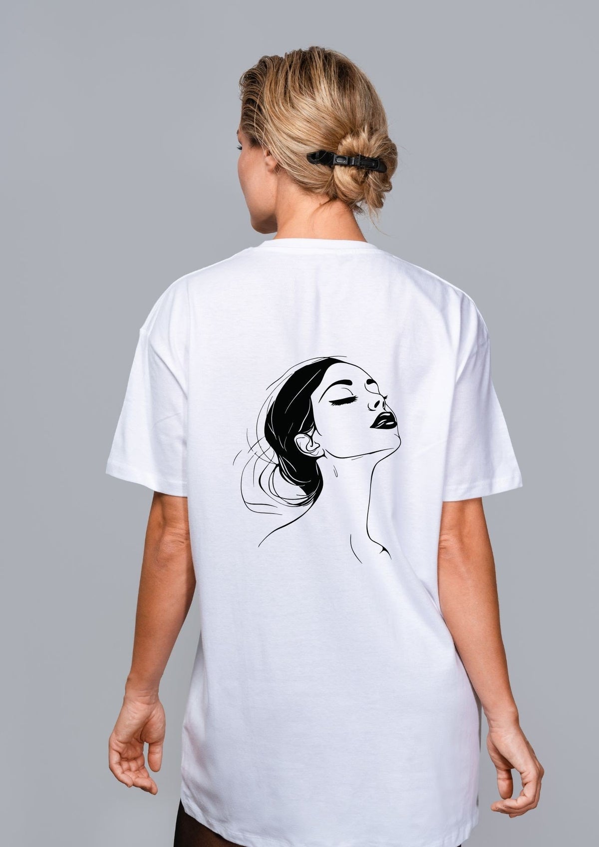 2. Woman shown from back wearing white T-shirt with black line art illustration on grey background