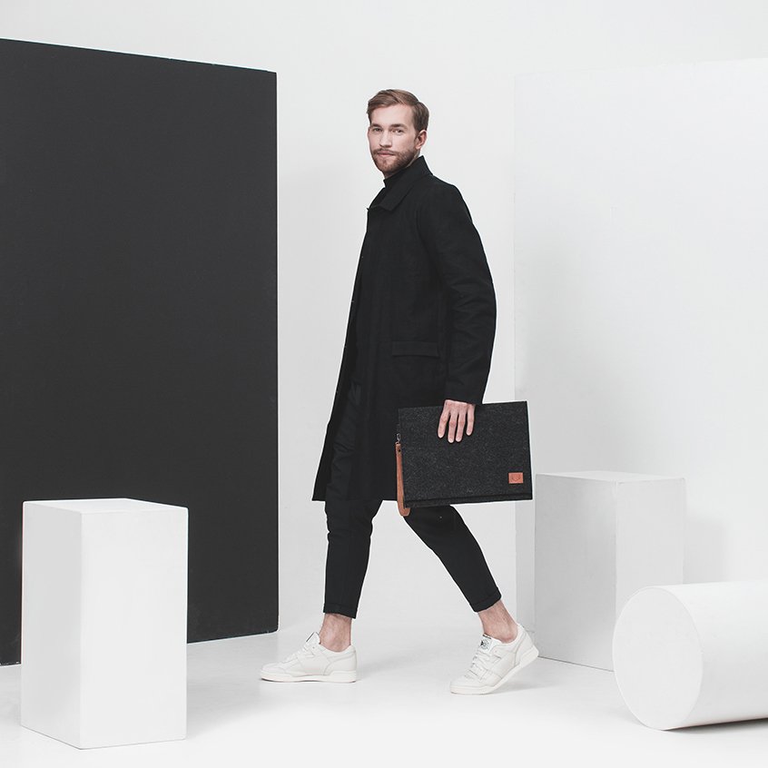 2. Men's Nordhale Berg black laptop bag held by model in minimalist studio setting