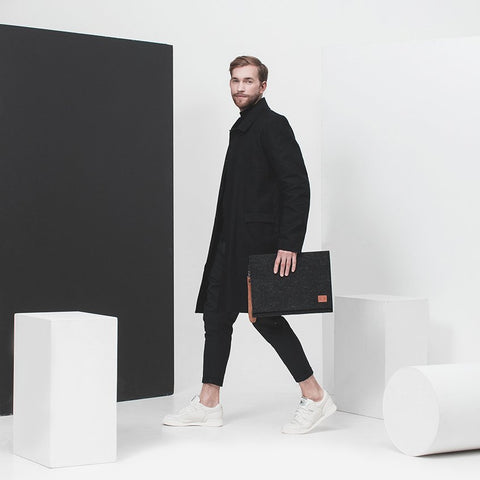 2. Men's Nordhale Berg black laptop bag held by model in minimalist studio setting