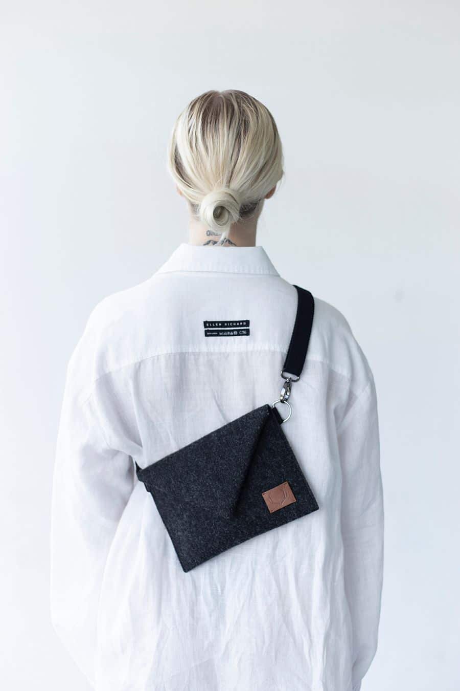2. Women's Skive-mini crossbody bag by Nordhale worn on back, shown with white shirt in studio
