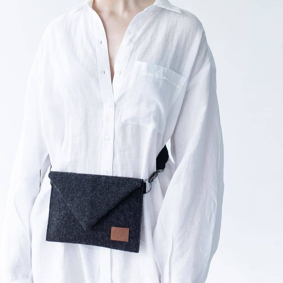 8. Women's Skive-mini crossbody bag by Nordhale worn on waist, shown with white shirt in studio