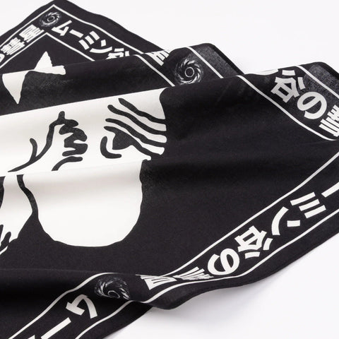 2. Close-up of black Moomin scarf showing white character and Japanese text border on cotton fabric