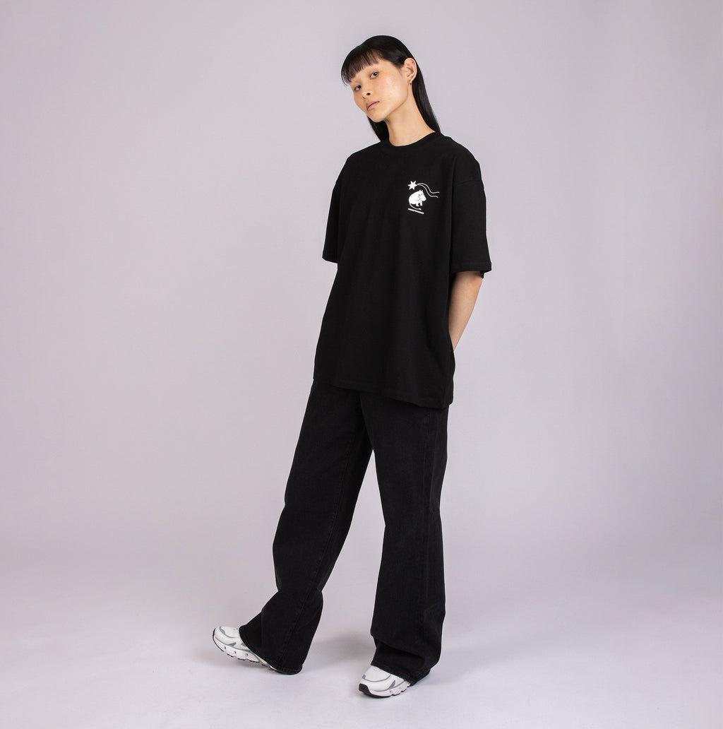 4. Female model in black Moomin t-shirt with subtle front logo, styled casually in studio
