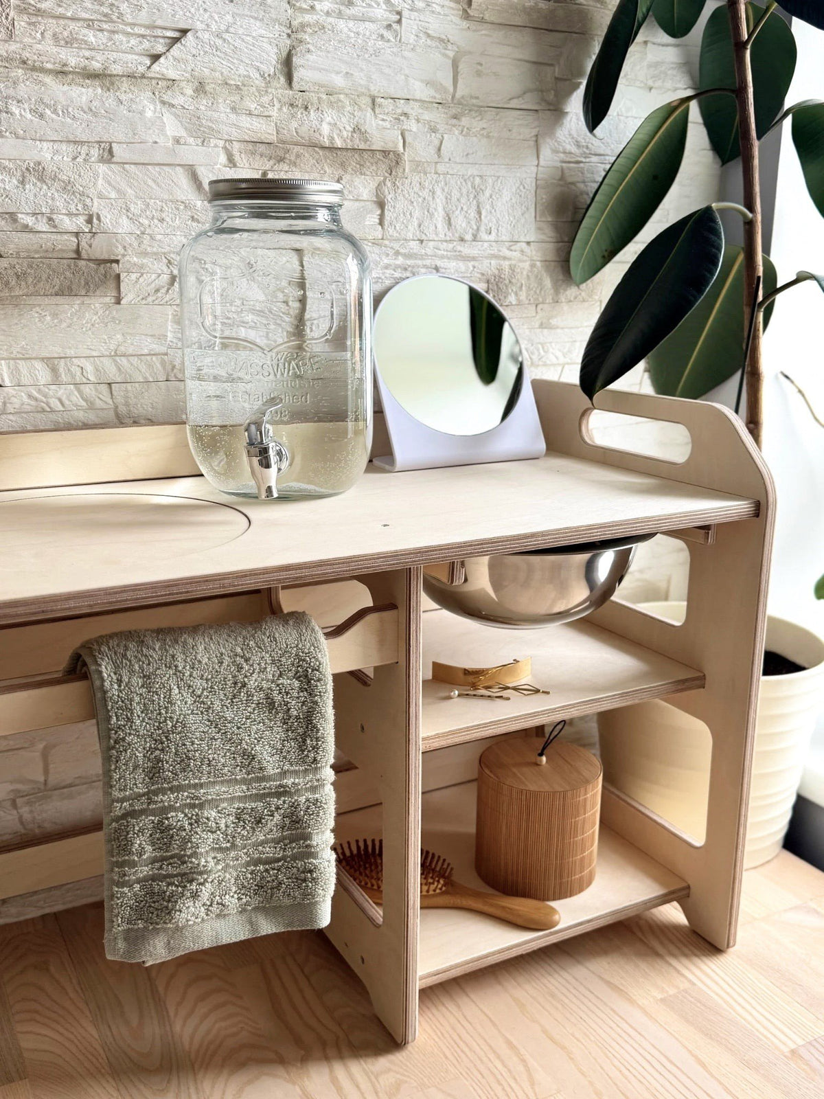 10. Montessori washbasin with towel, enamel bowl, and open storage shelves