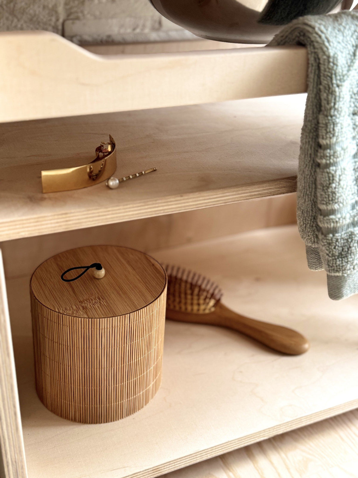 7. Close-up of lower shelf on Montessori washbasin with wooden container and brush