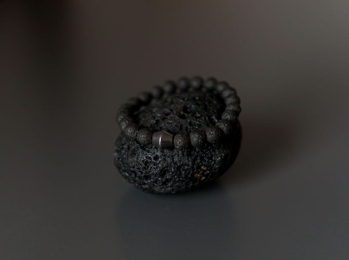 3. Close-up of Obsidian Lava Stone Bracelet by Canary Lava on lava rock, highlighting texture and Obsidian stone