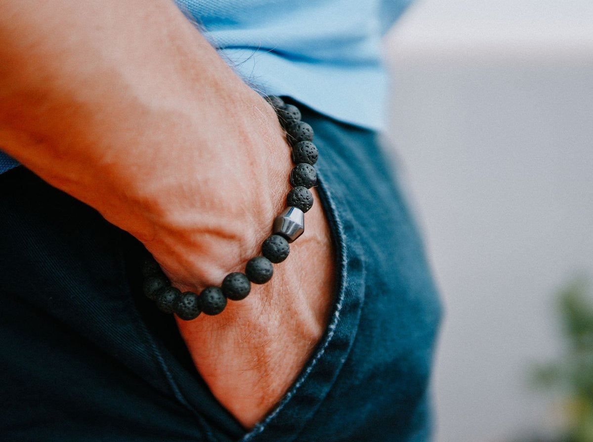 1. Men's Obsidian Lava Stone Bracelet by Canary Lava worn on wrist, showcasing polished lava rocks and Obsidian stone