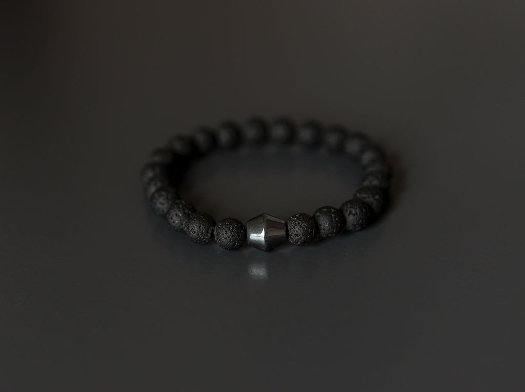 2. Studio image of Obsidian Lava Stone Bracelet by Canary Lava, featuring polished lava rocks and central Obsidian stone