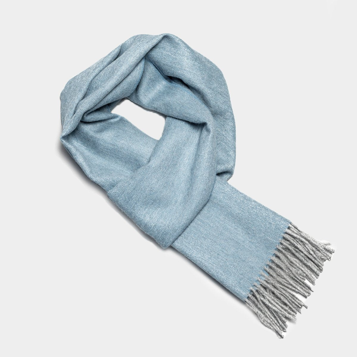 15. Studio image of Alpaka natural baby alpaca wool scarf in light blue with fringe detail