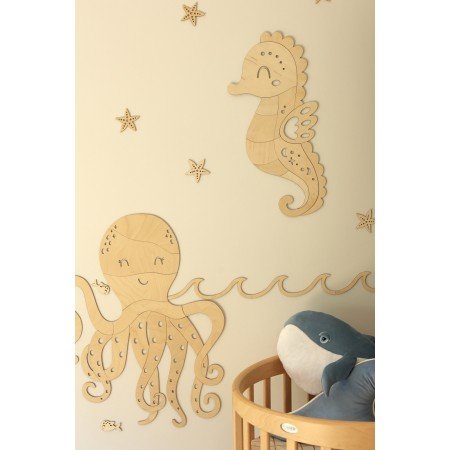 3. Wooden octopus and seahorse wall decorations above a crib, enhancing an ocean-themed nursery setting