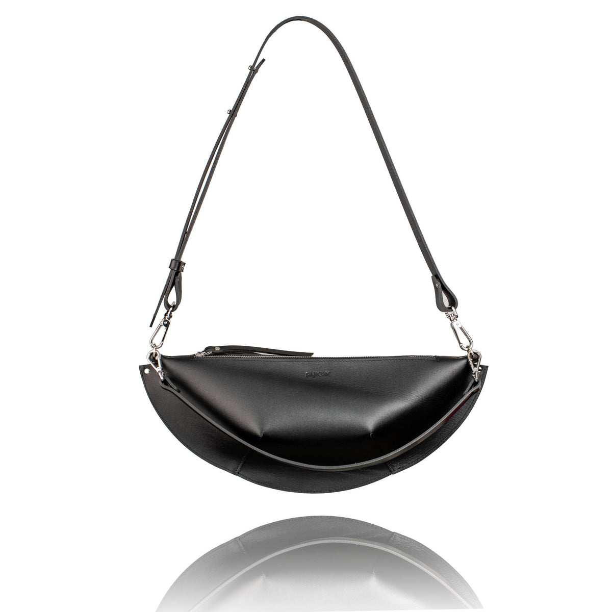 3. Studio image of PYKOK Olivia black leather handbag with long adjustable strap and geometric shape