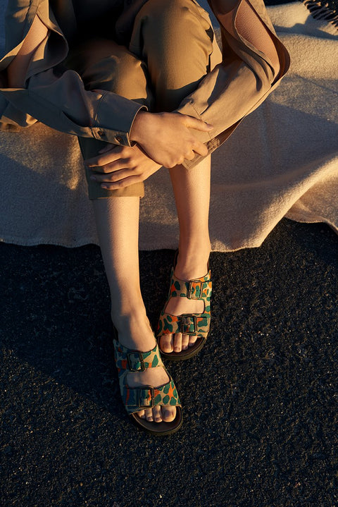 2. Close-up of woman's feet in Omaking Meeliku Sandals, multicolor, on a blanket