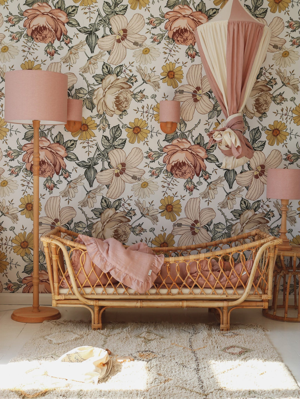 8. Powder pink and cream canopy in a floral-themed room with wicker furniture, creating a vintage and cozy ambiance.