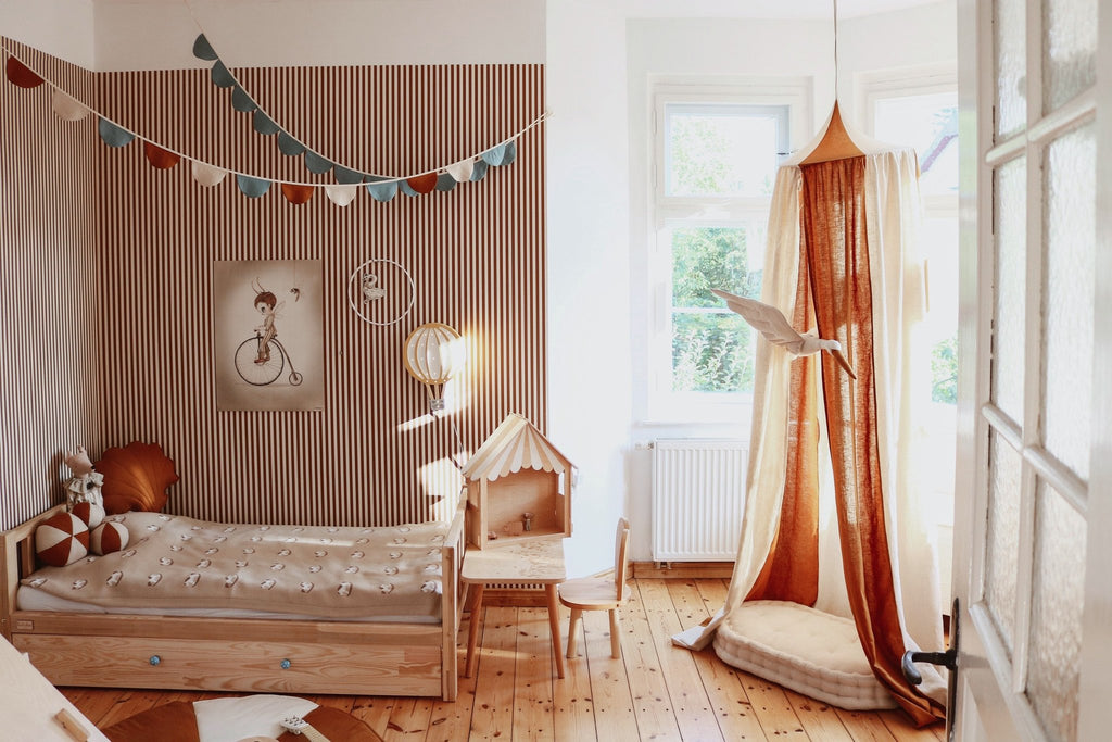12. Caramel and cream canopy in a child's room with wooden furniture and garlands