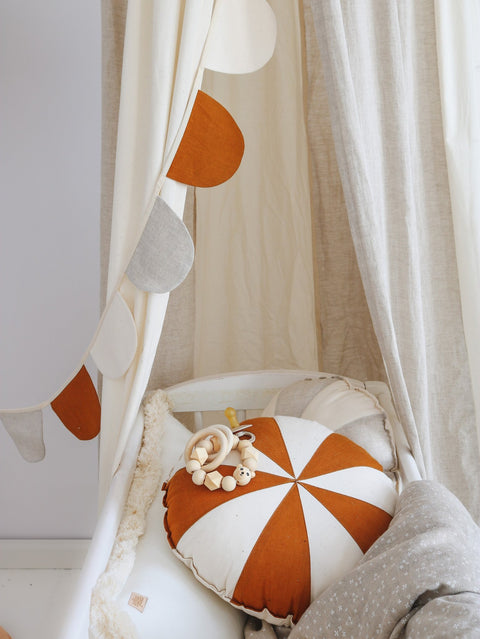4. Close-up of cream canopy interior with orange and white cushion and garland