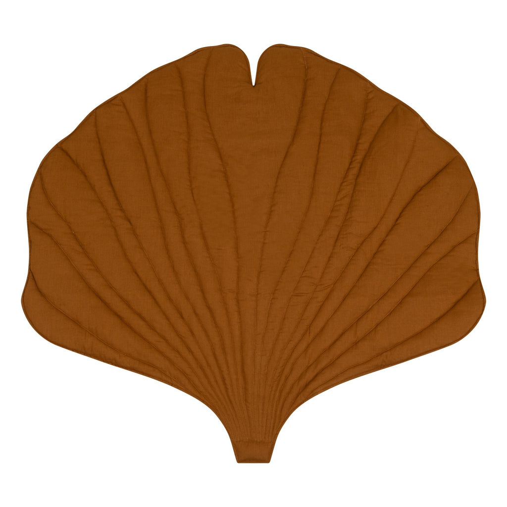 2. Studio shot of caramel-colored ginkgo leaf-shaped playmat made from organic cotton and linen, highlighting its unique design and texture
