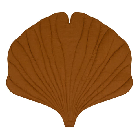 2. Studio shot of caramel-colored ginkgo leaf-shaped playmat made from organic cotton and linen, highlighting its unique design and texture