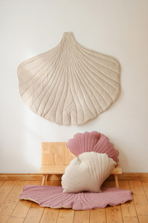 1. Cream ginkgo leaf playmat on a wall with pink and cream cushions on a wooden bench, creating a playful and inviting space