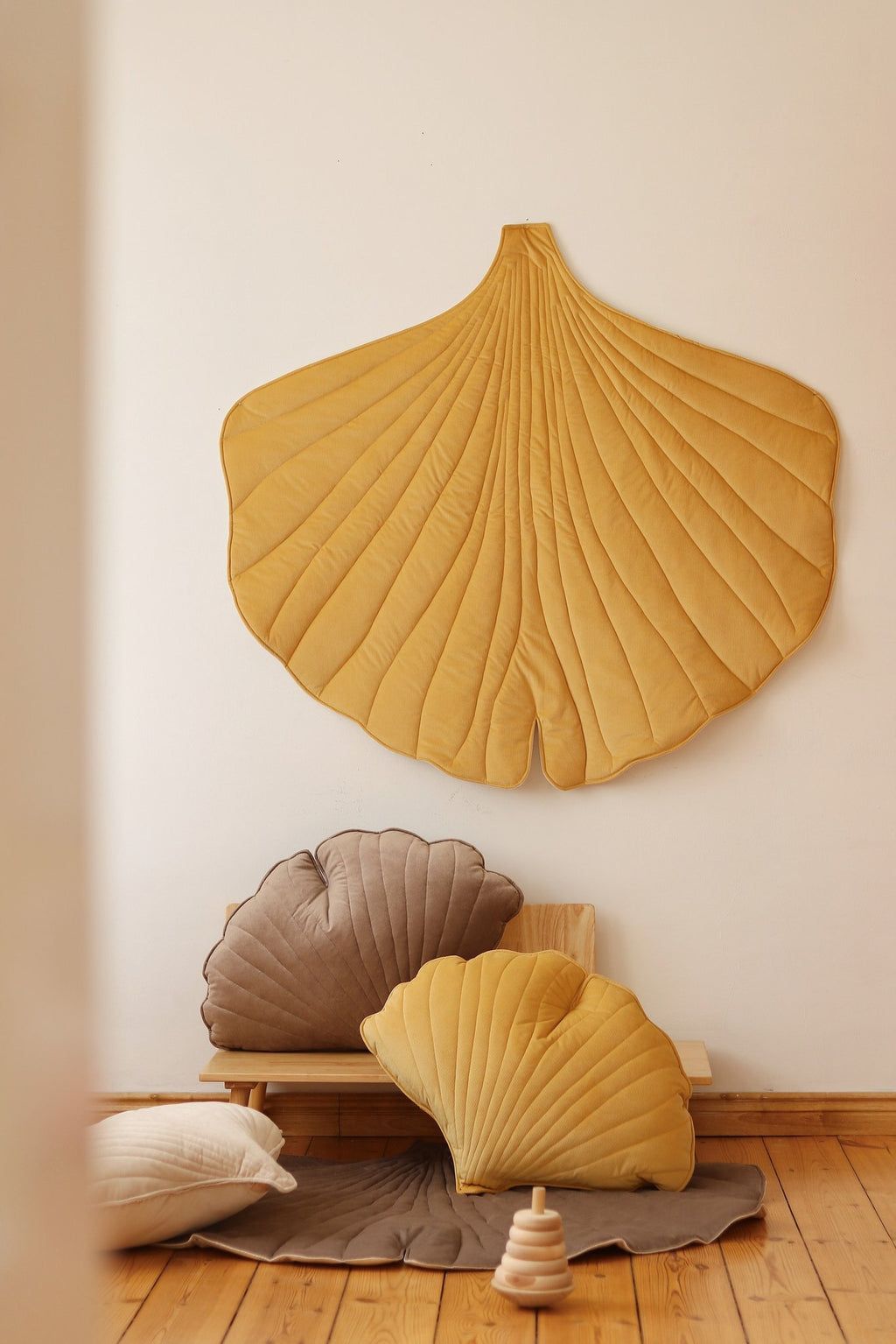 7. Yellow ginkgo leaf playmat with brown and yellow cushions in a room