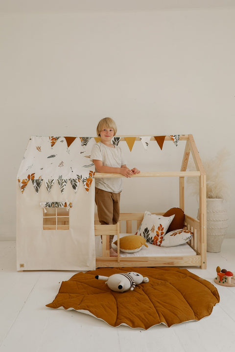 1. Child standing in a wooden playhouse with caramel leaf playmat on the floor
