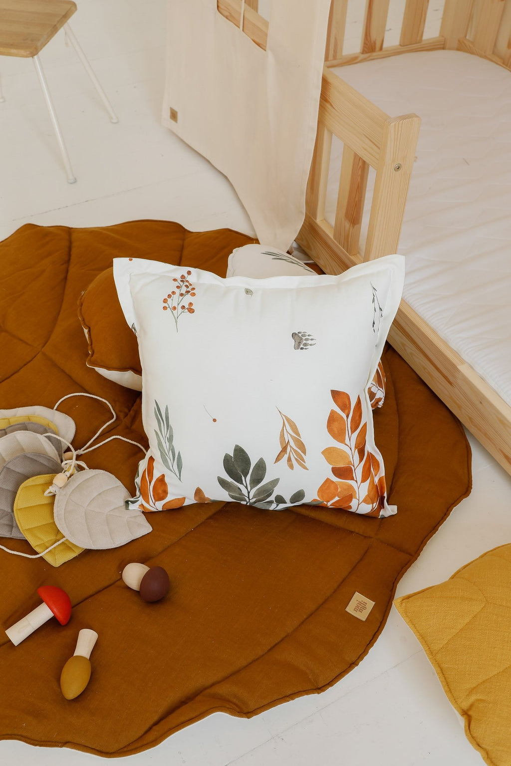 3. Close-up of caramel leaf playmat with decorative pillow and toys in a child's room