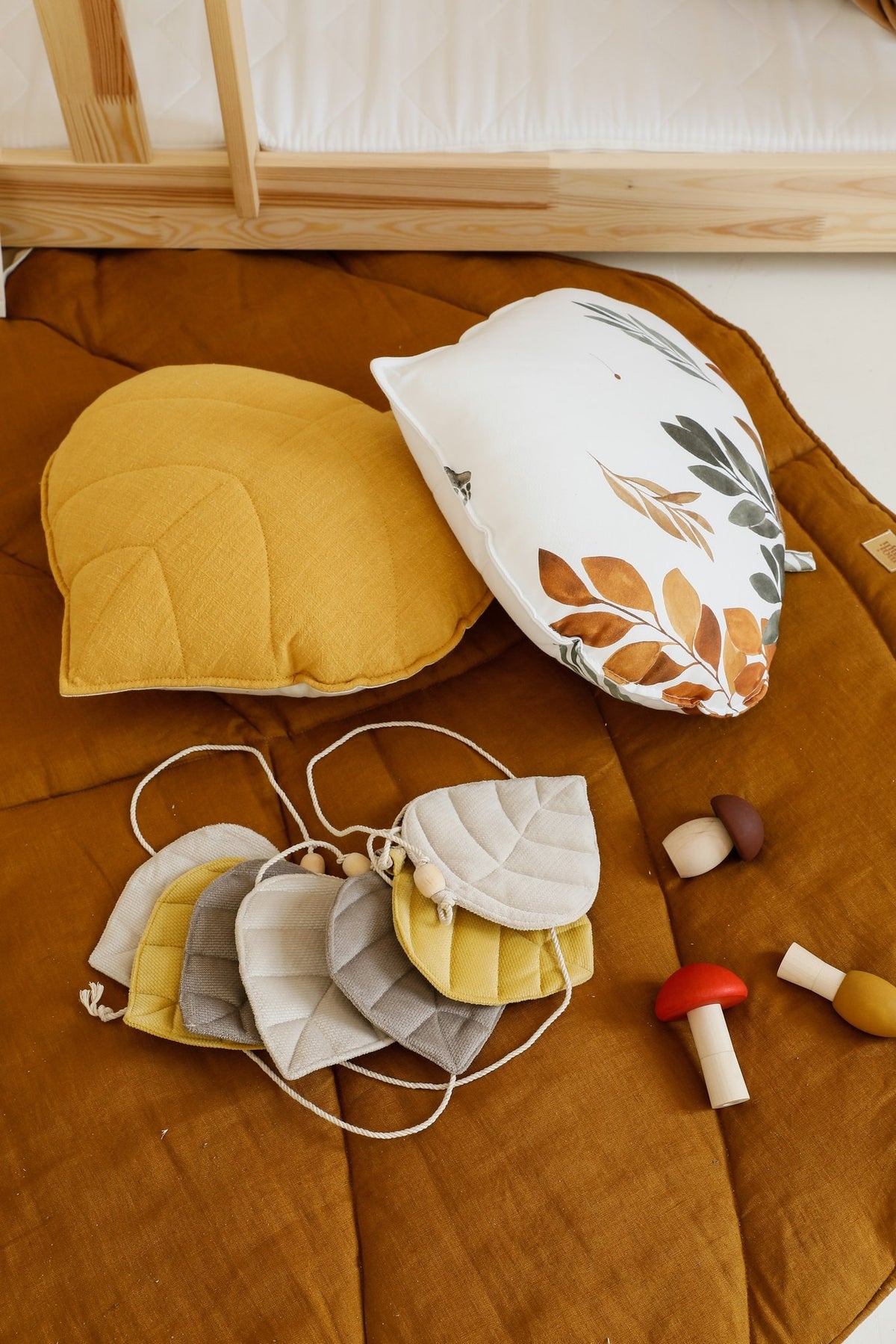 3. Close-up of caramel playmat with leaf-shaped cushions and toys