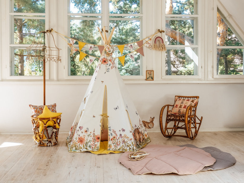 1. Powder pink leaf playmat in a children's room with a floral teepee and wooden rocking chair