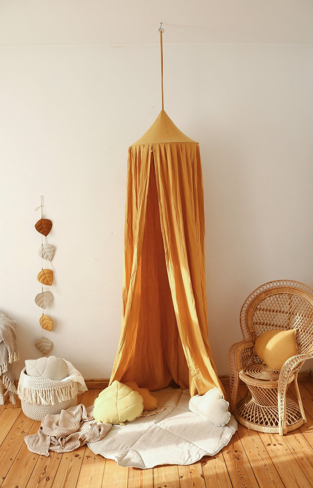 8. Sand playmat under mustard canopy with wicker chair and decor in cozy room