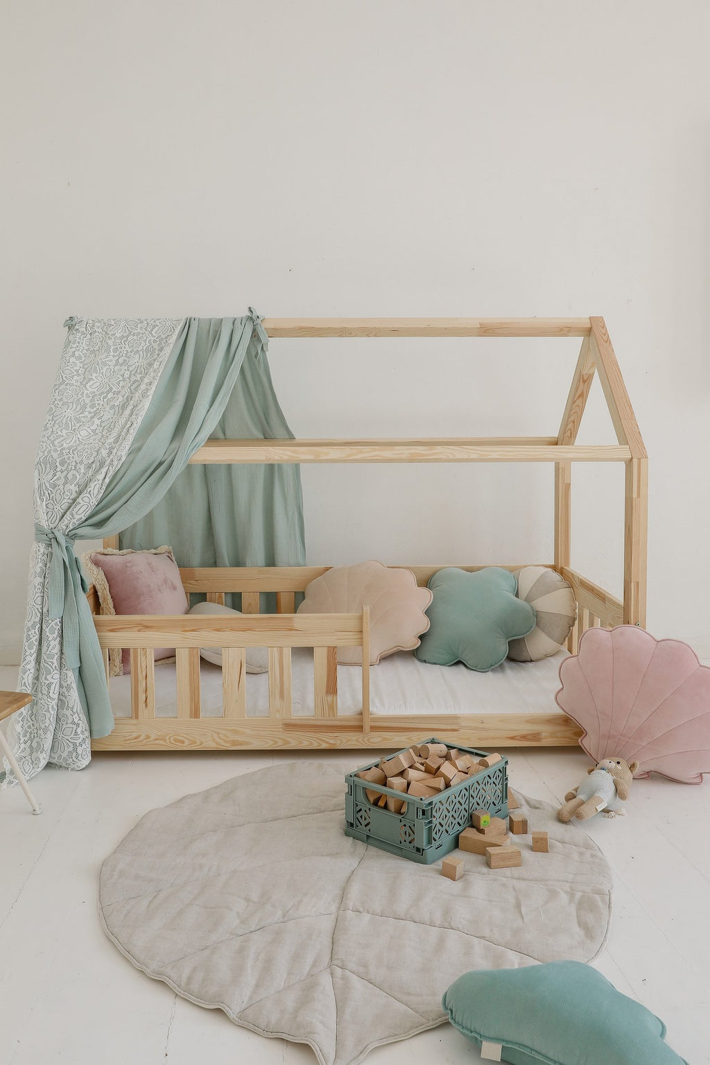 10. Sand playmat in children's room with wooden bed, pastel pillows, and toys