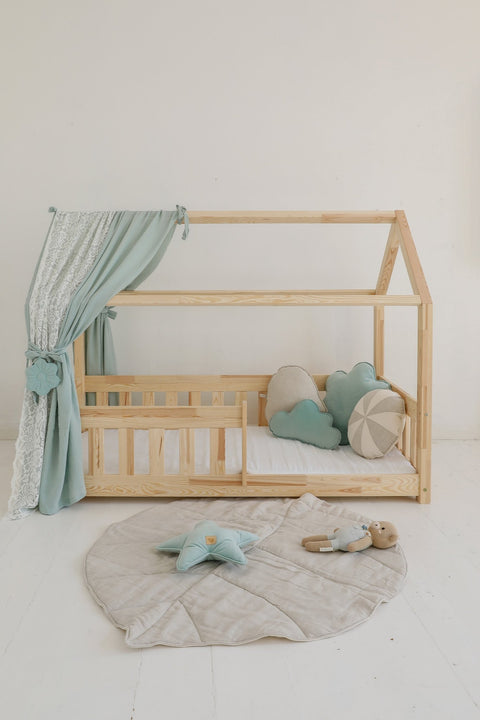 3. Sand leaf playmat in nursery with wooden bed, blue curtains, and plush toys