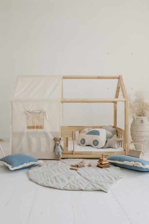 4. Sand playmat in children's room with wooden bed, car pillow, and blue cushions