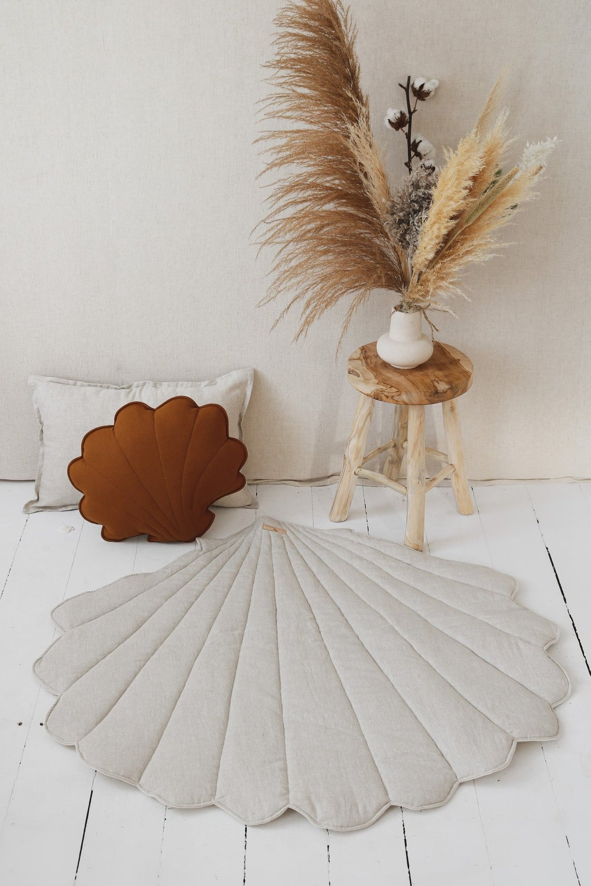 2. Organic cotton and linen shell playmat in sand color on white wooden floor with decorative plants