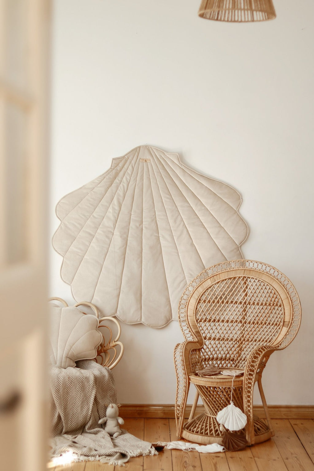3. Beige ginkgo leaf-shaped playmat on wall with wicker chair and decor in room