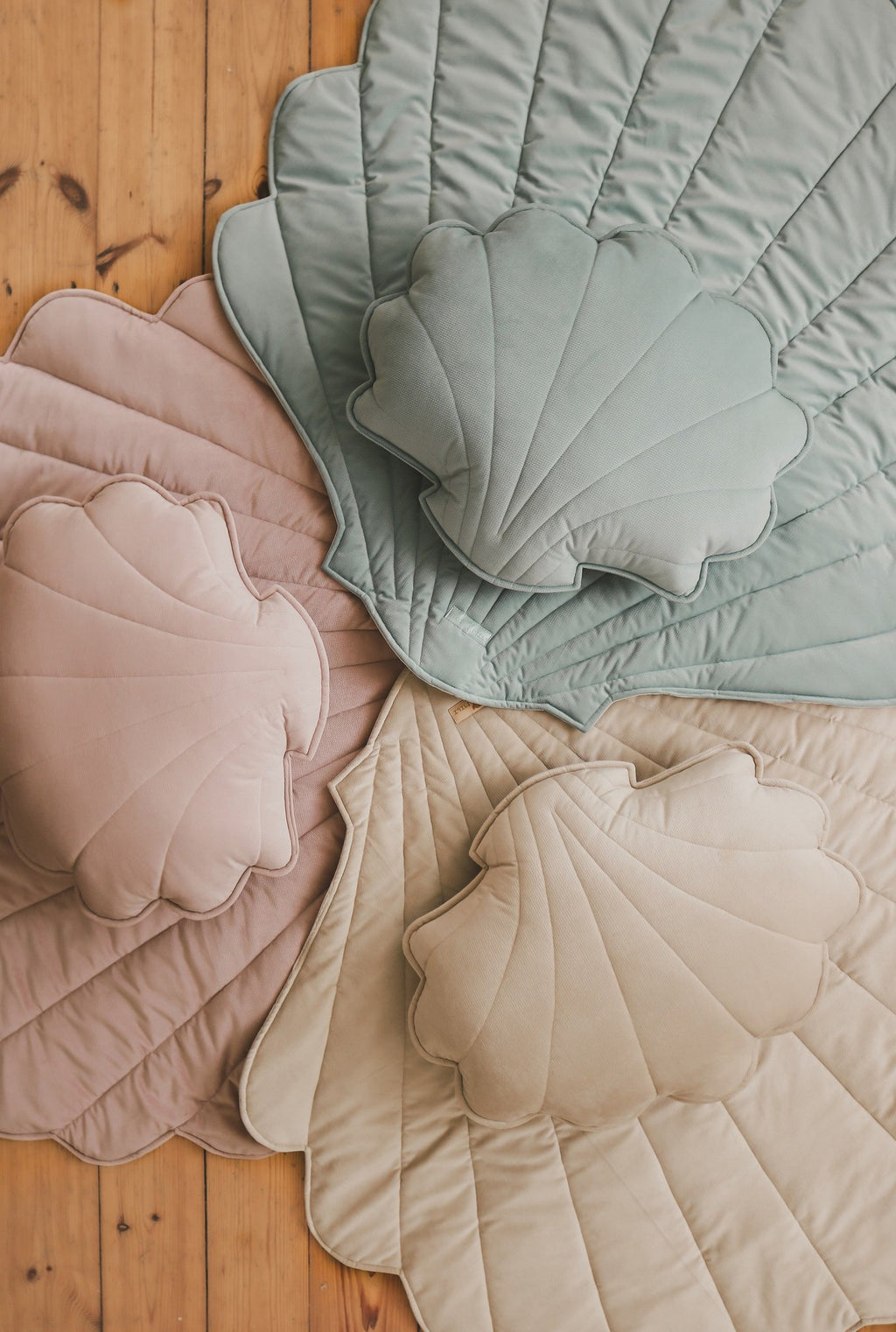 10. Beige, pink, and green ginkgo leaf-shaped playmats with shell cushions on wooden floor