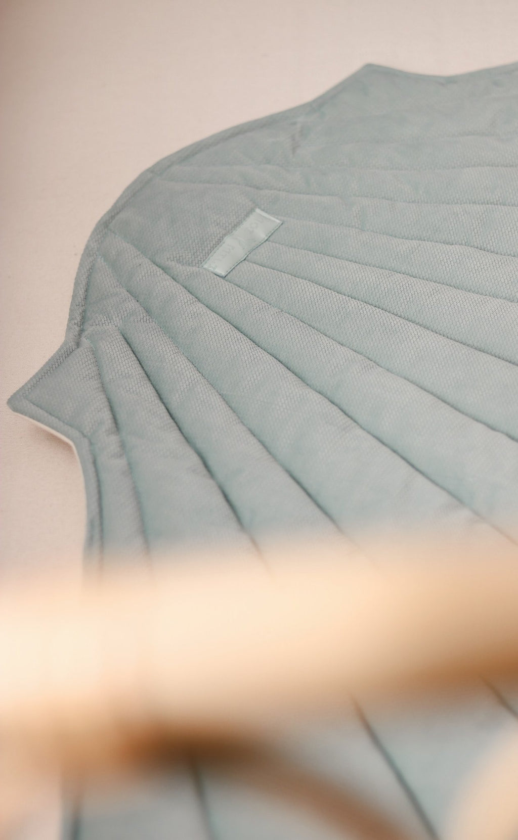 3. Close-up of mint green shell playmat showing quilted texture and stitching detail