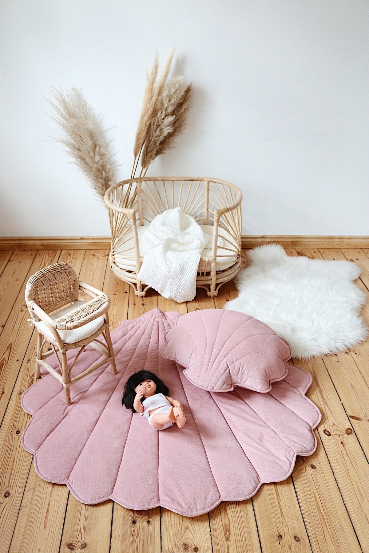 5. Powder pink shell playmat with matching pillow and doll in nursery setting