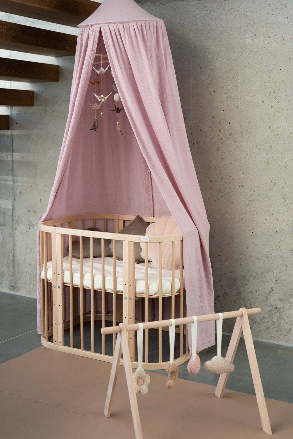4. Pink canopy over crib with wooden play gym in minimalist nursery