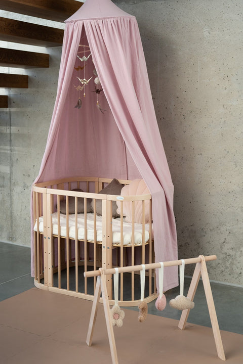 4. Pink canopy over crib with wooden play gym in minimalist nursery