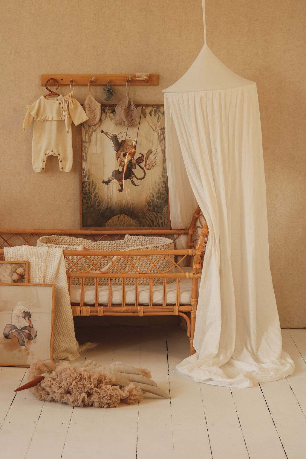 1. Cream cotton canopy over a wicker crib in a nursery with decorative wall art