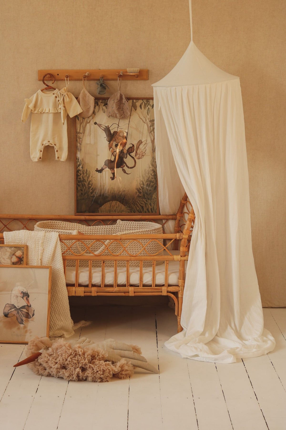 1. Cream cotton canopy over a wicker crib in a nursery with decorative wall art