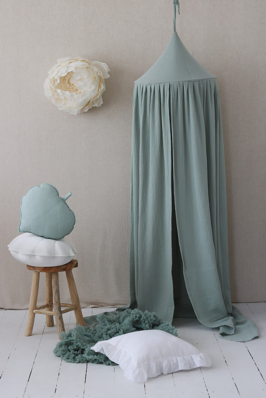 1. Mint green cotton canopy with decorative pillows and stool in a cozy room setting