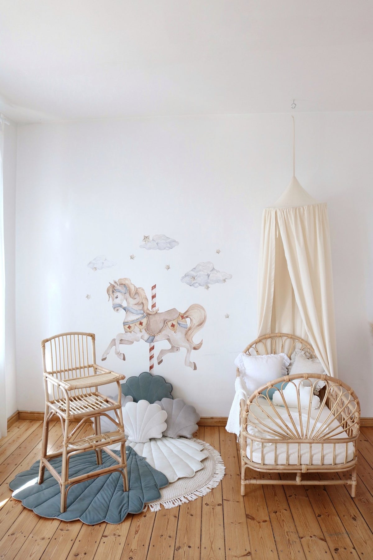 8. Nursery with organic cotton canopy, rattan crib, and horse wall art