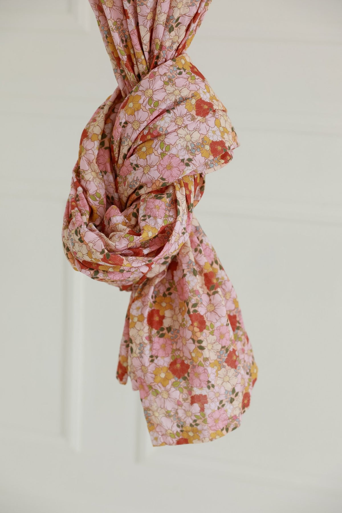 13. Close-up of knotted floral fabric in pink and orange hues