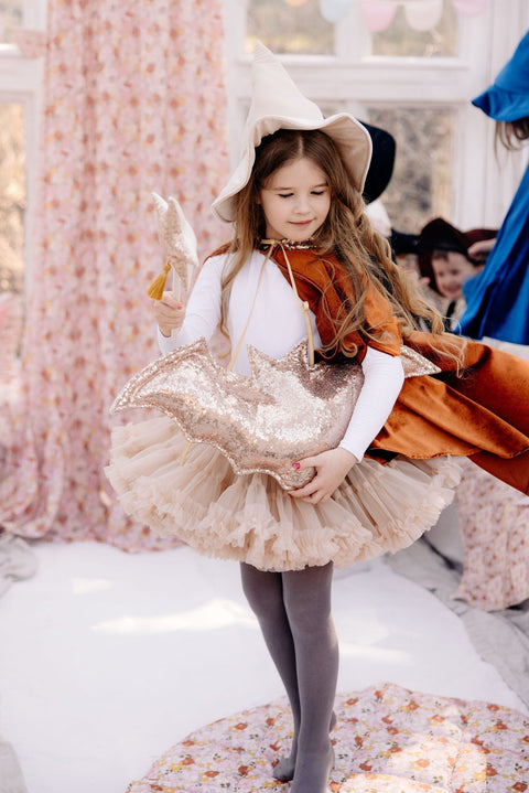 4. Girl in costume standing near floral canopy in a playroom setting