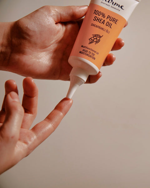 3. Close-up of Nurme 100% Pure Shea Oil being dispensed from twist cap tube onto fingertip