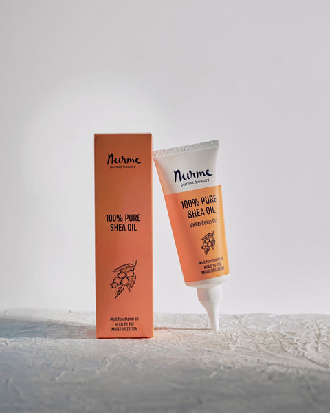 1. Nurme 100% Pure Shea Oil in eco-friendly twist cap tube with packaging on textured surface