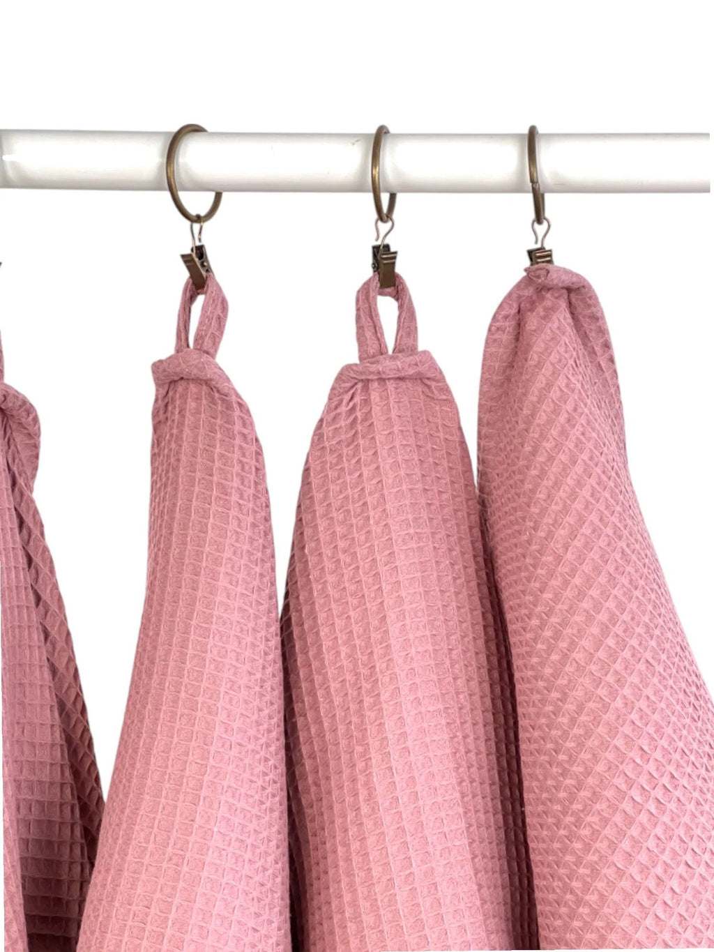 5. Close-up of old pink waffle cotton towels hanging on hooks, focusing on texture and loops