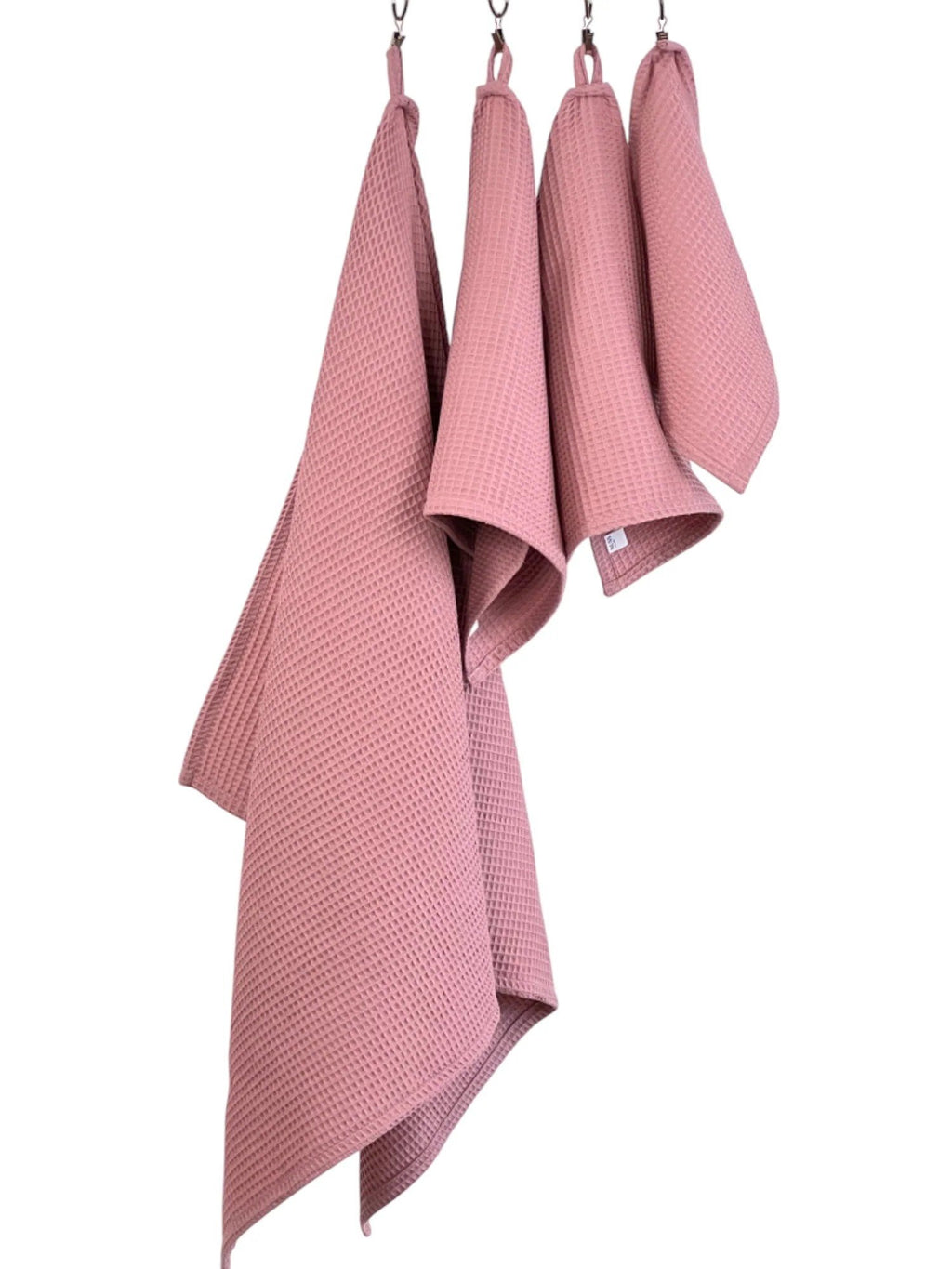 7. Old pink waffle cotton towels in different sizes hanging, showcasing versatility