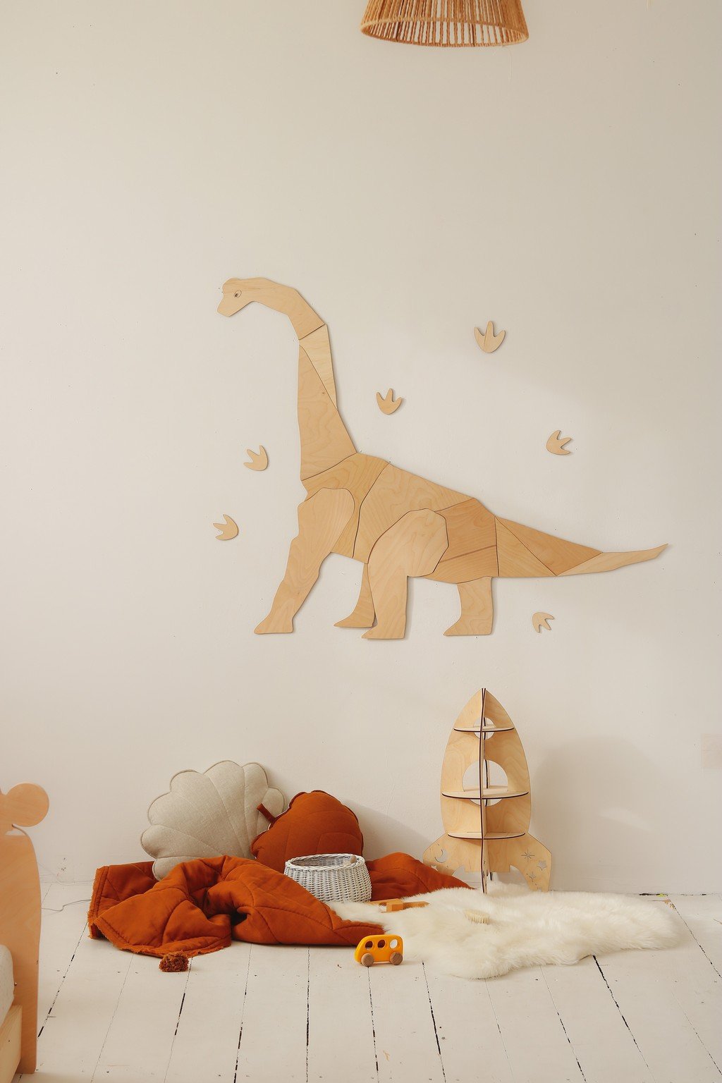 6. Wooden diplodocus wall art in cozy children's room with soft toys and decor