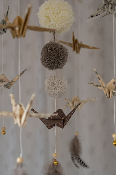 5. Detail of Moi Mili origami mobile with paper cranes, yarn pompoms, and feathers